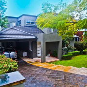 Contemporary residential house in Sydney with lush garden and paved driveway.