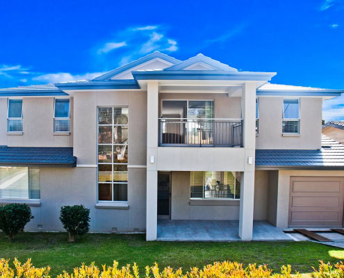 Modern Sydney home with balcony, large windows, and garage.